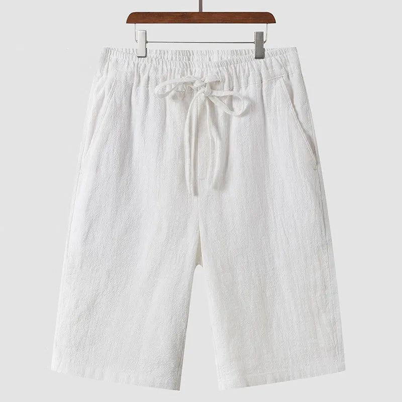 Men's loose-fit linen shorts in a cropped mid-length style with an elastic waistband.