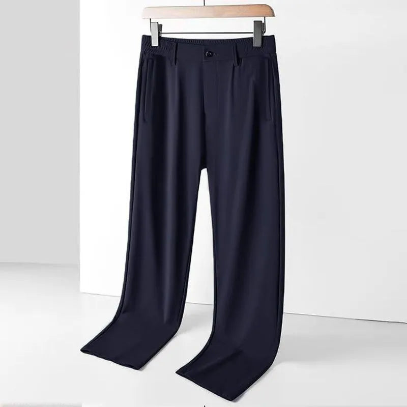 Man wearing black ice silk straight leg loose fit casual trousers with an elastic waistband