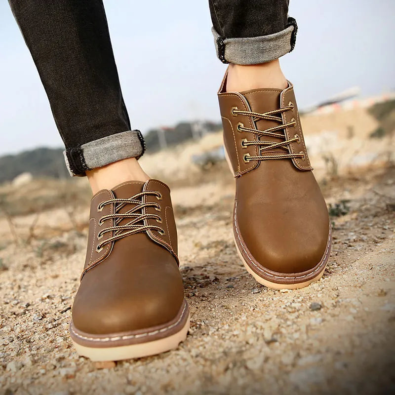 Men's black mid-top British style leather boots with a flat rubber sole.