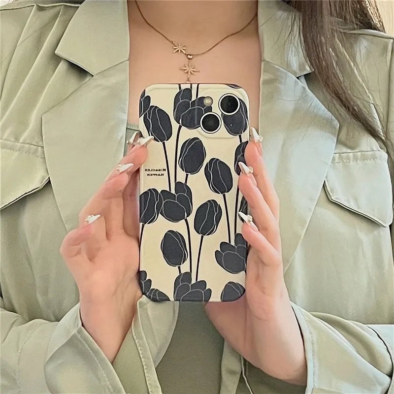 Black silicone iPhone case with a printed tulip floral design on the back.