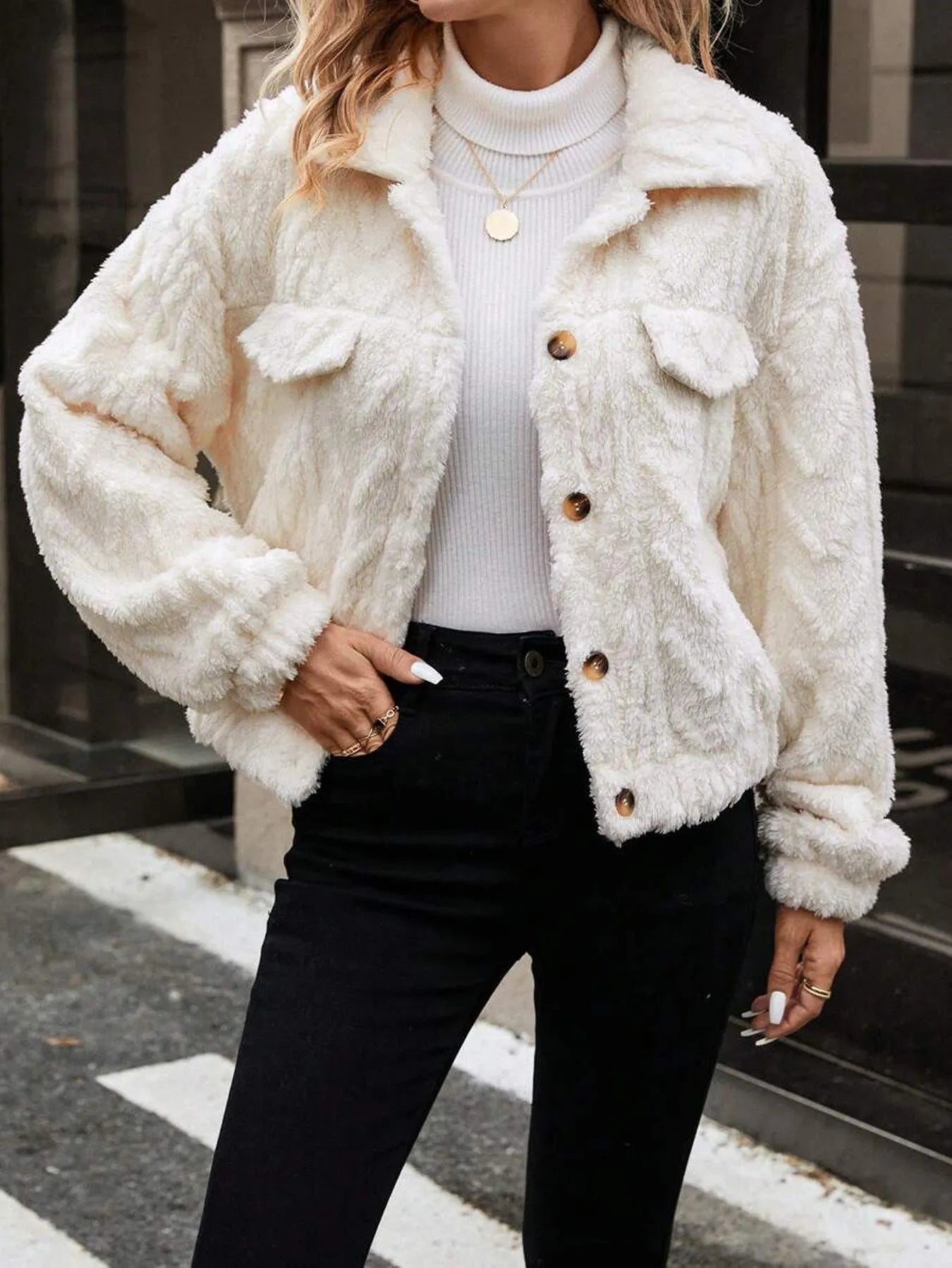 Ivory white women's cardigan coat with buttons and plush fabric on a hanger.