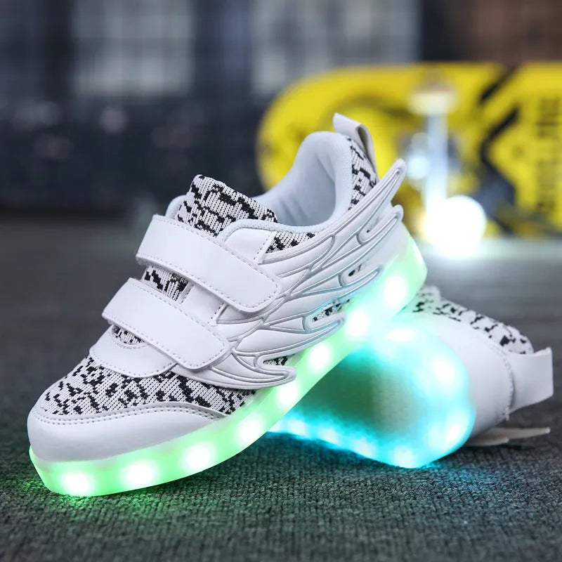 Plum red children's sneakers with LED lights glowing on the soles, showing USB charging port.