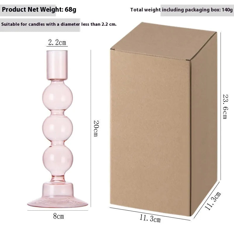 Transparent borosilicate glass three ball mott candle holder in green on a table