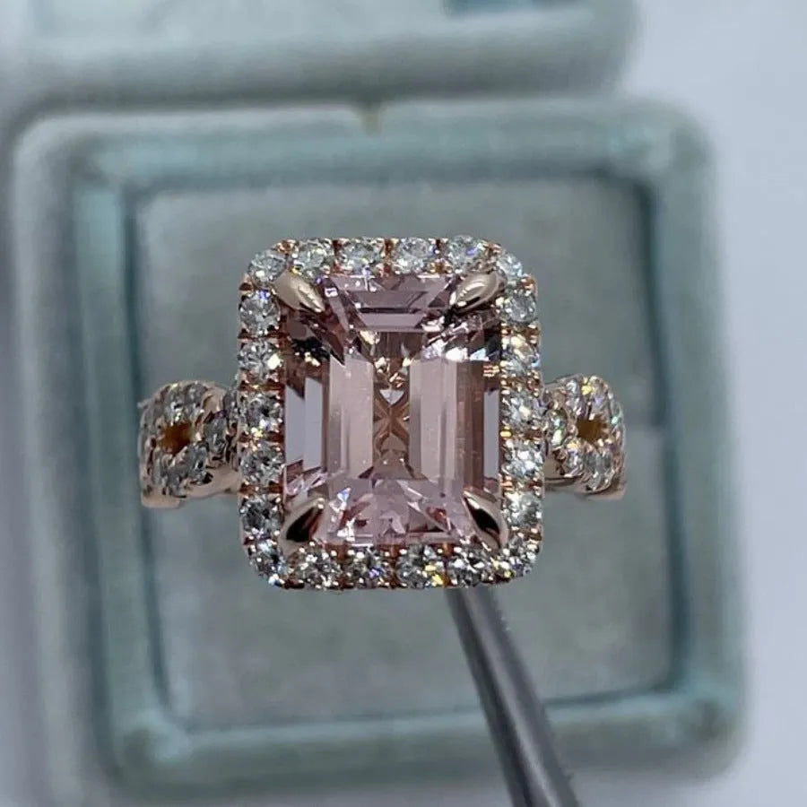 A geometric-shaped rose gold alloy ring on a plain background.