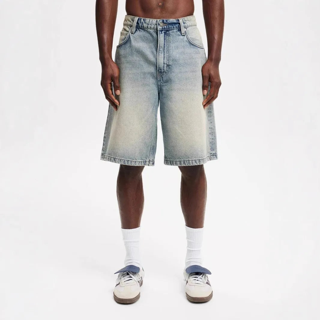 Men's loose fit light blue denim jeans with straight leg on a neutral background