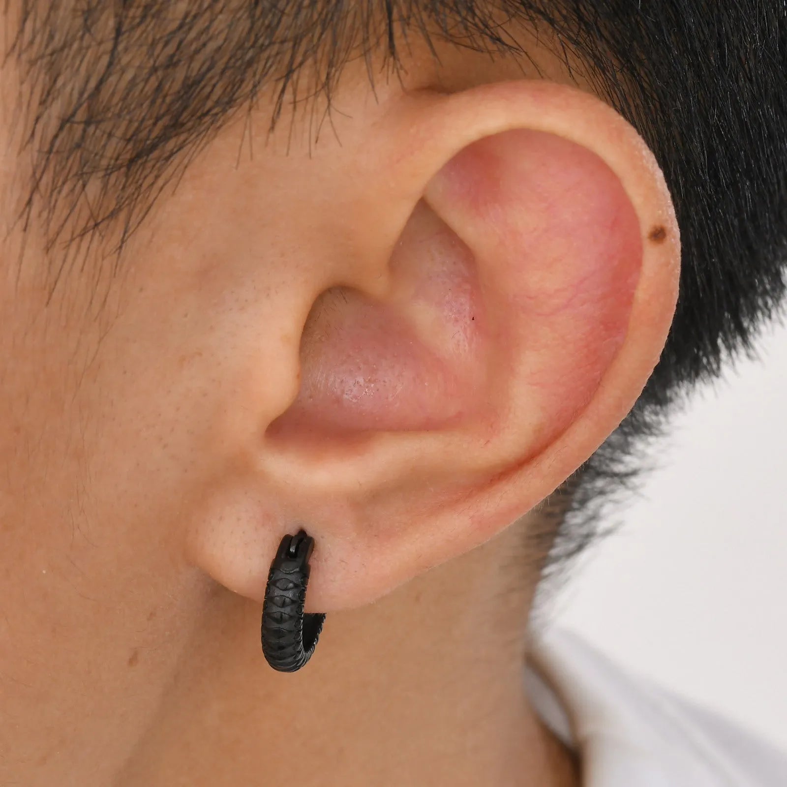 Stainless steel snake pattern hip hop ear ring in black finish showing textured surface