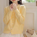 Women's solid colour cardigan sweater with bow-shaped pearl buttons on the front.