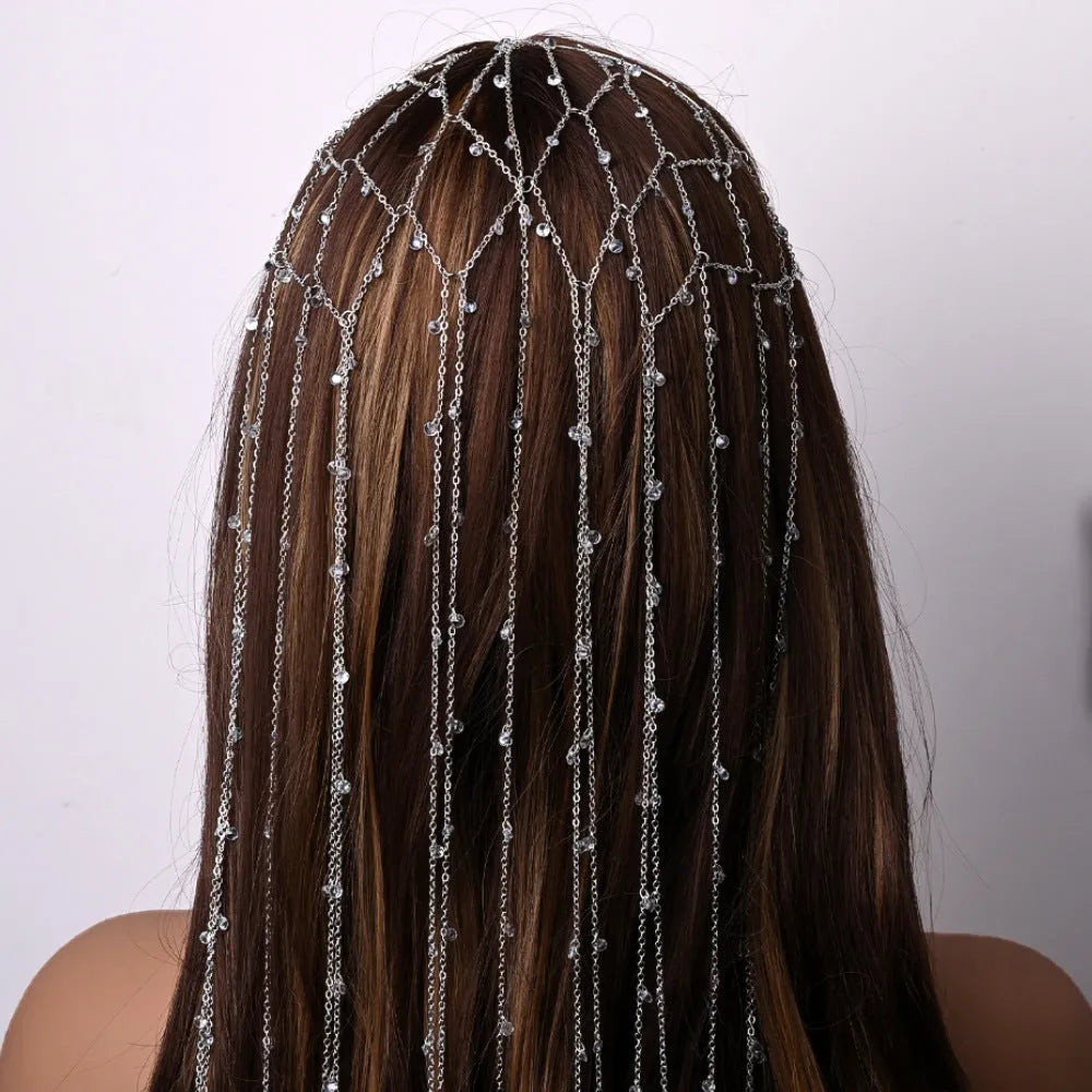 Gold rhinestone headband with mesh tassel detail on a white background.