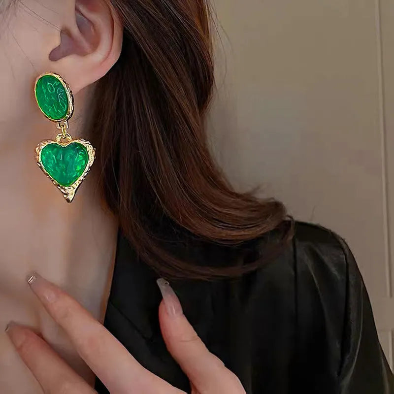 Silver textured oval love heart stud earrings in purple, red, green, and yellow white on a jewellery card.