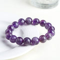 Natural feather amethyst crystal bracelet with scattered beads and a Ruyi symbol in Snow Mountain purple.