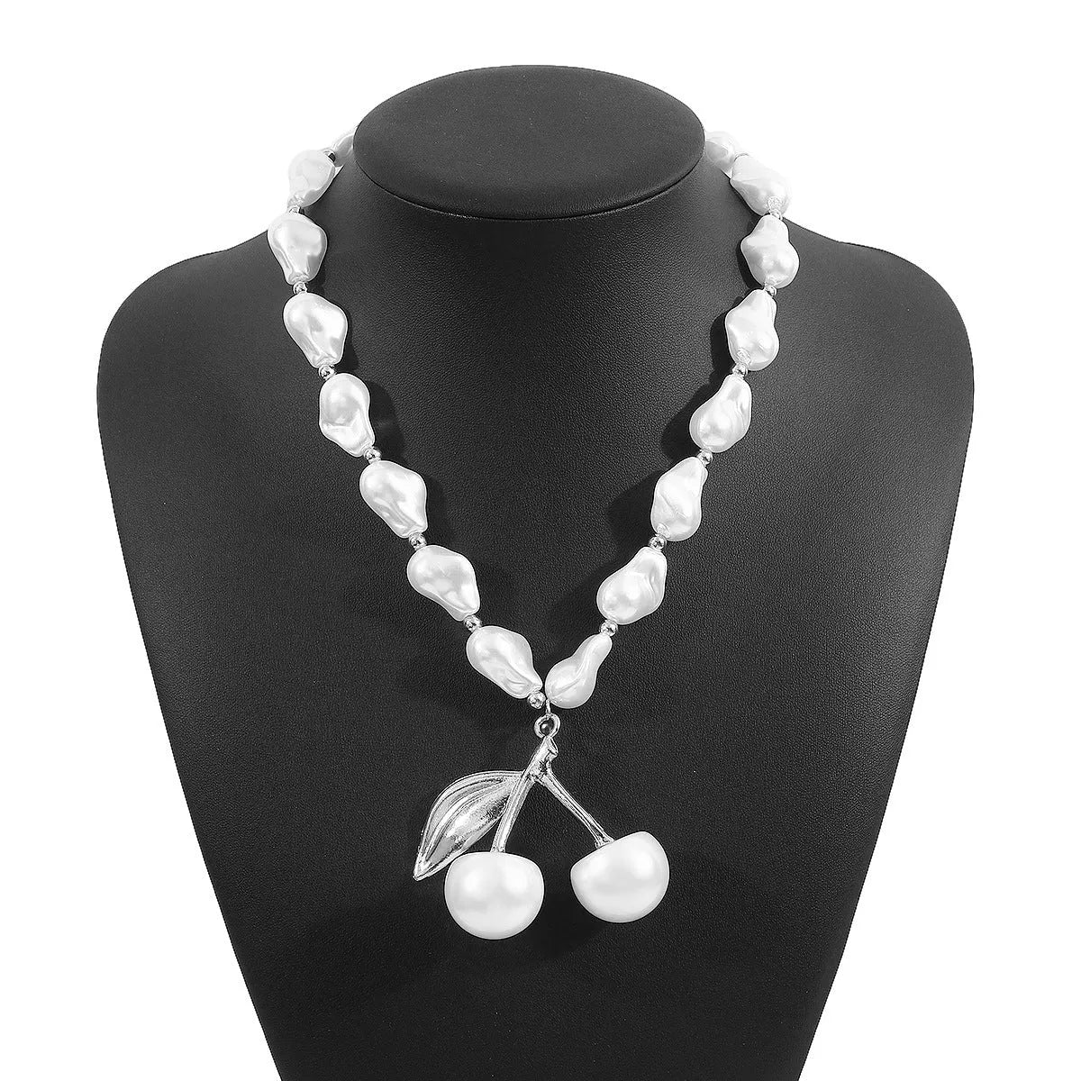 Gold and white alloy necklace with irregular cherry fruit and pearl pendant on a pearl chain.