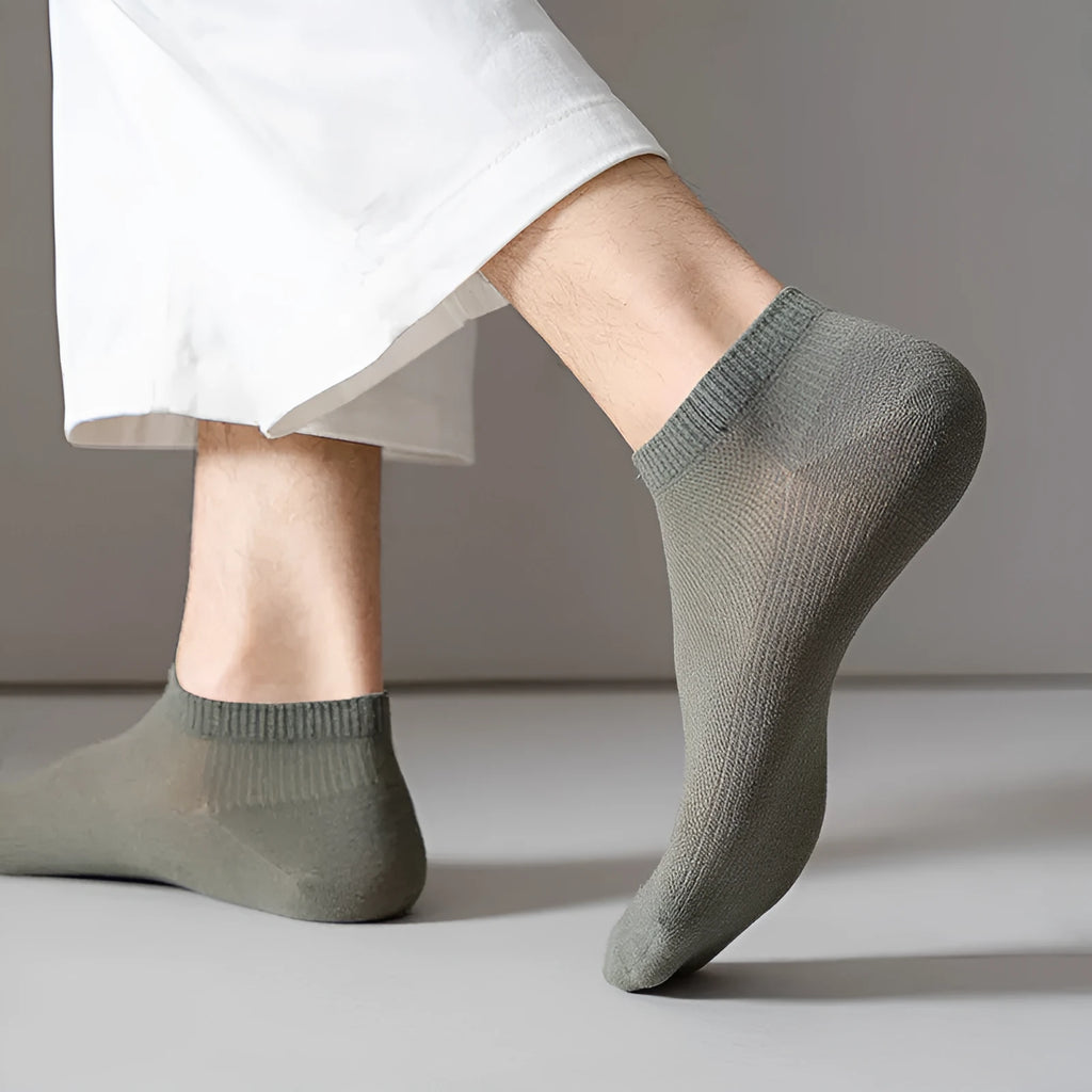 A pair of solid colour low-cut polyester boat socks for men, shown in one of six available colours.