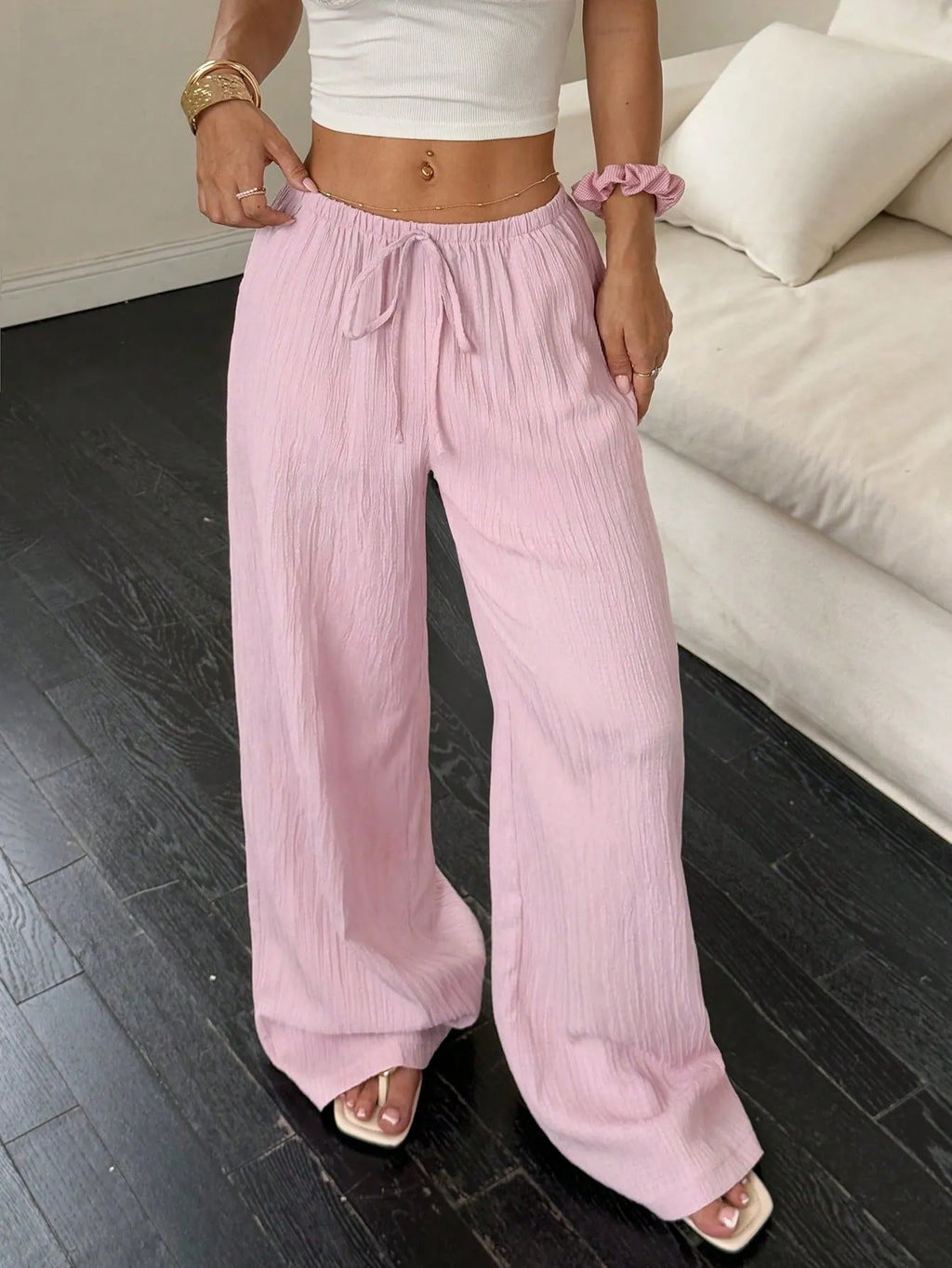Women's black casual trousers with a lace-up waist detail and wide-leg silhouette.