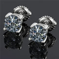 Close-up of silver geometric moissanite stud earrings with screw claw setting on a black card.