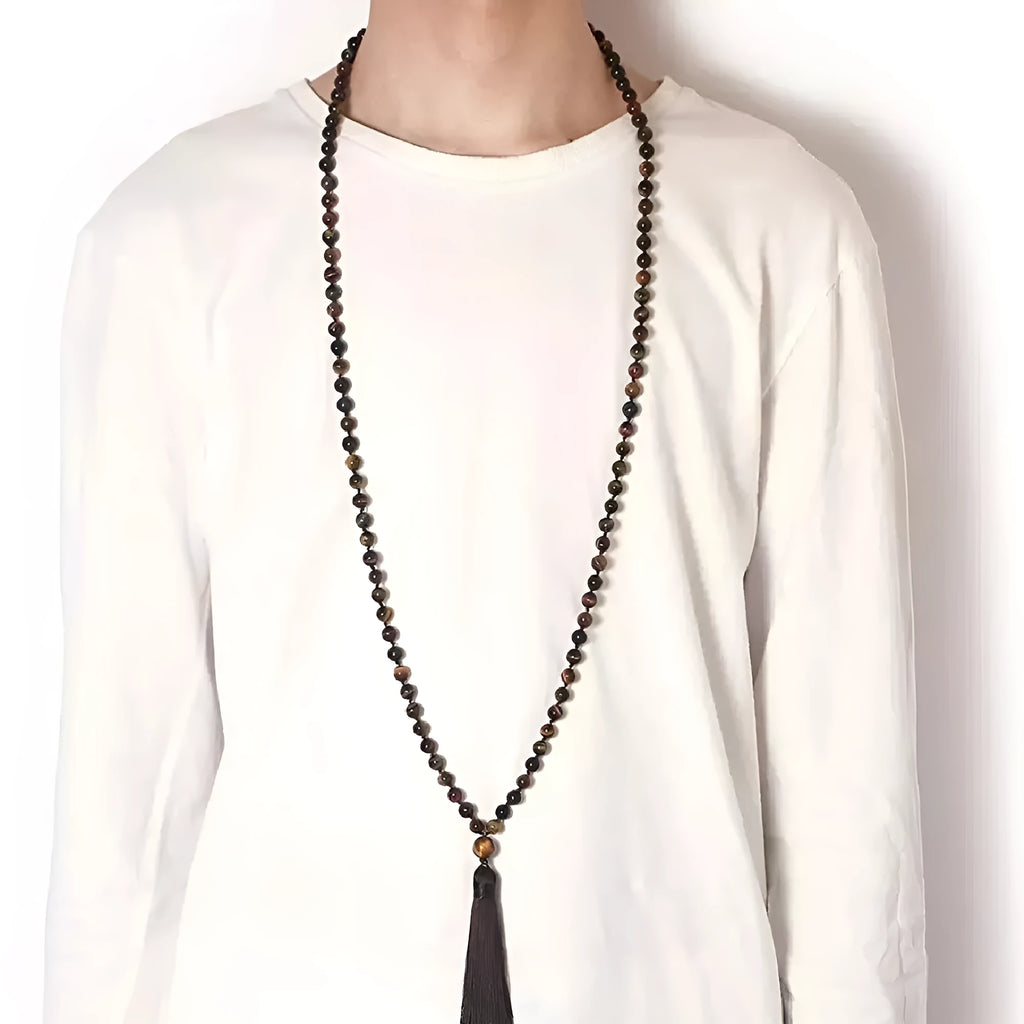 Long geometric agate and gemstone tassel necklace with blue, purple, and multi-coloured beads on a black background.