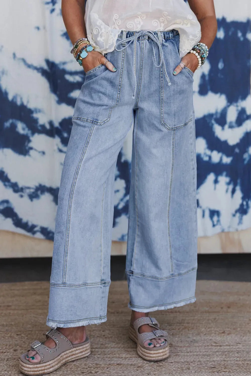 Beau Blue women's wide leg denim trousers featuring a drawstring waistband and raw hem detailing.