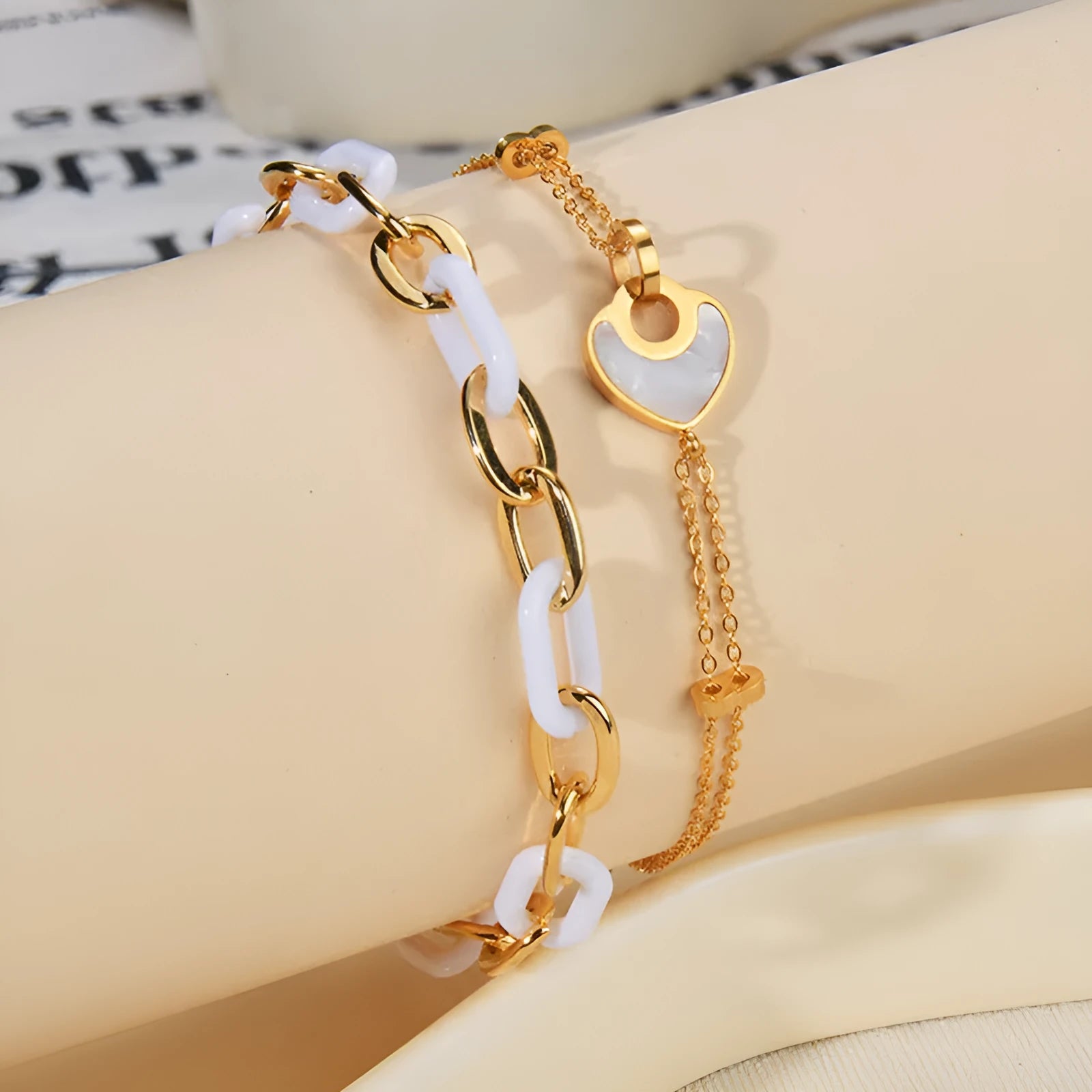 Close-up of a women's stainless steel bracelet featuring a double-layer heart charm with resin details.