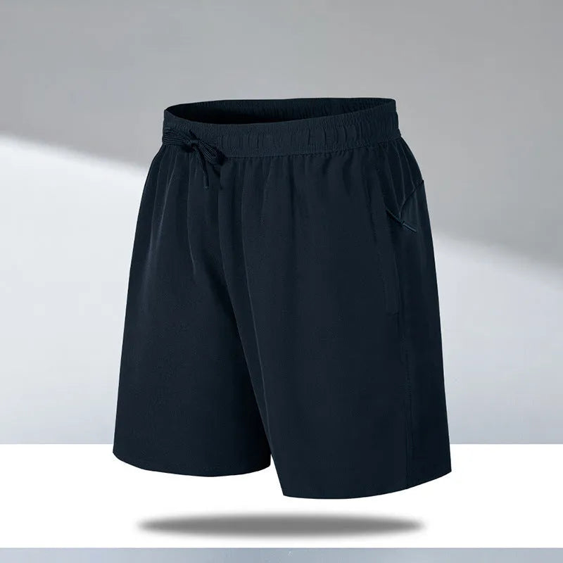 Man wearing loose-fit black quick-drying ice silk polyester sports shorts on a beach.