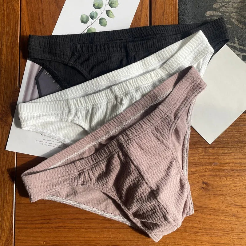 Men's solid colour cotton triangle briefs in apricot, shown from the front on a mid-waist fit model.