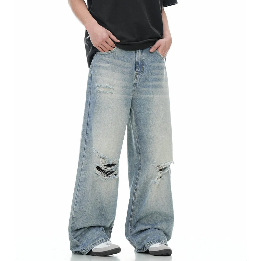 Men's blue straight leg jeans with ripped detailing on a cotton blend fabric.