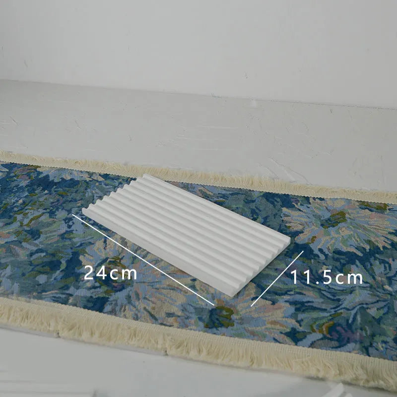 Handmade plaster jewellery display tray with necklaces and bracelets on a countertop