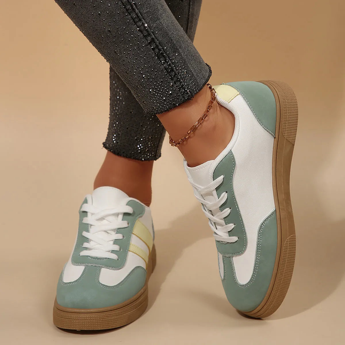 Green retro sports women's pumps with cross straps, leather stitching, round toe, and a low flat rubber sole.