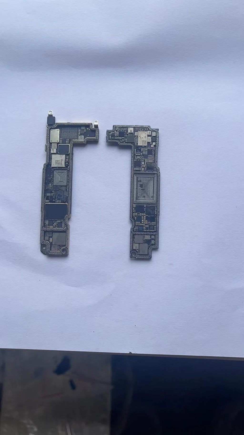 Silver-coloured Apple iPhone logic board spare part for iPhone 12 series phones.