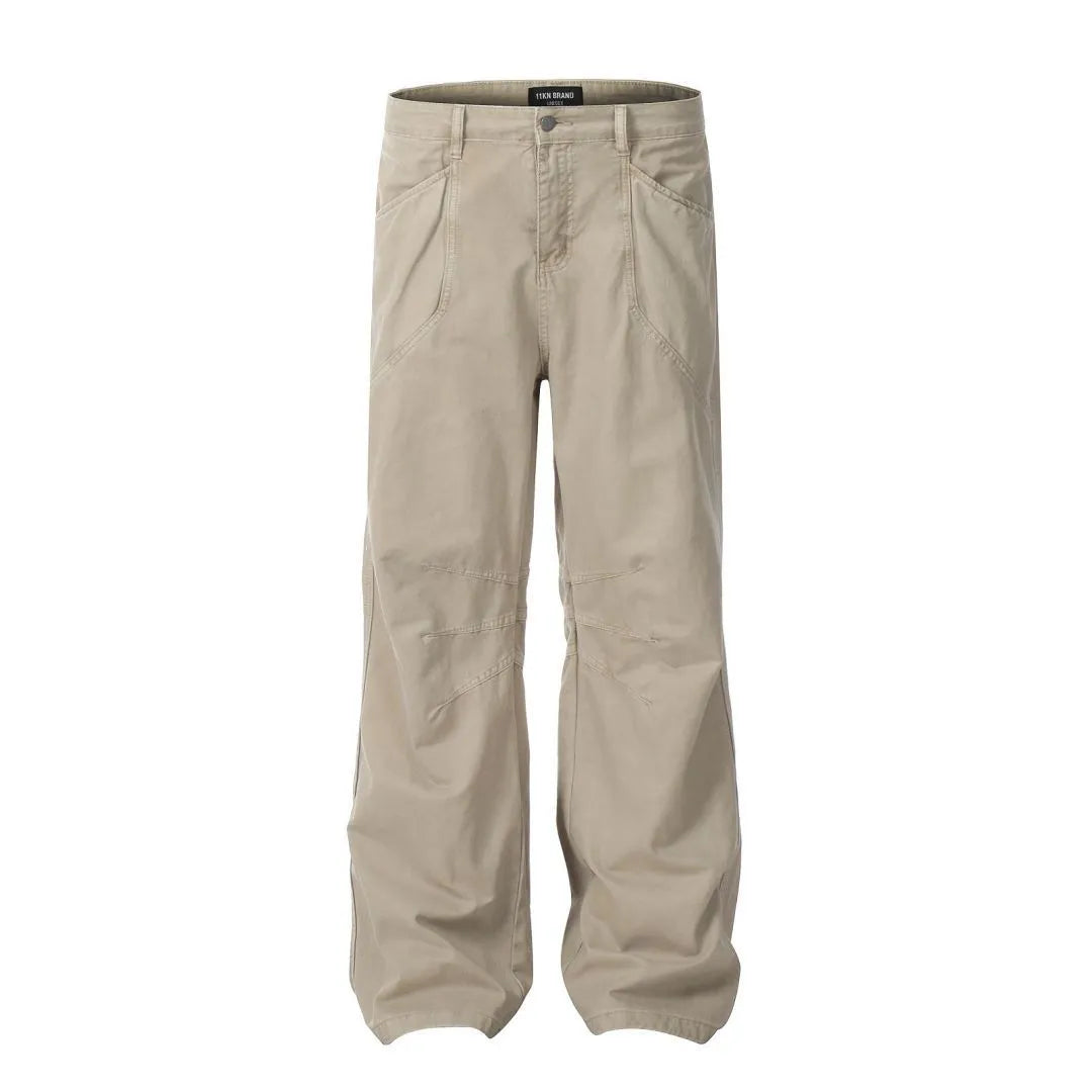 Men's loose straight-leg cotton trousers in brown, showing high waist and zipper fly.