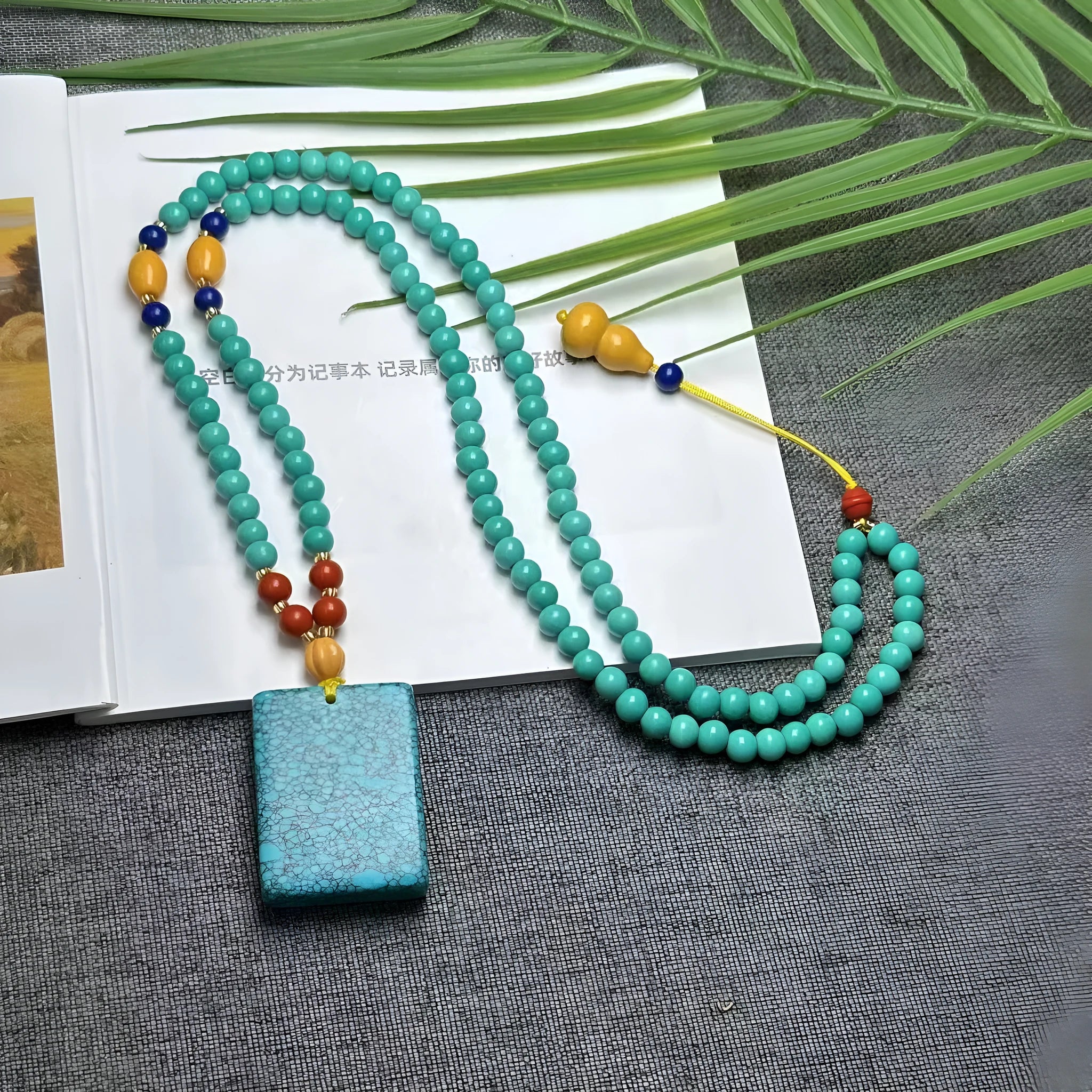Turquoise stone mesh flower pendant on a silver ball bead necklace, adjustable length.