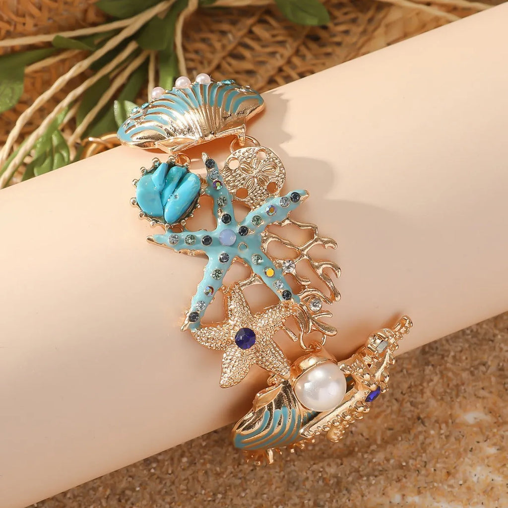 Women's alloy marine-themed bracelet with boat anchor, shells, starfish and rhinestones in turquoise, red or blue.