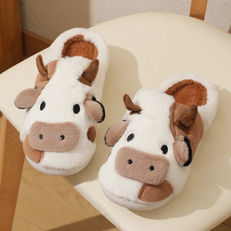 White cartoon cow design faux fur slippers for women with a non-slip textured sole.