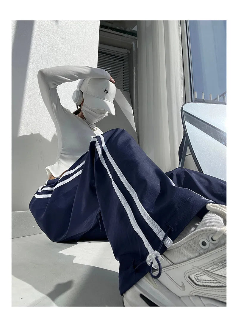 Women's navy blue straight leg trousers with a low waist and slimming drape.