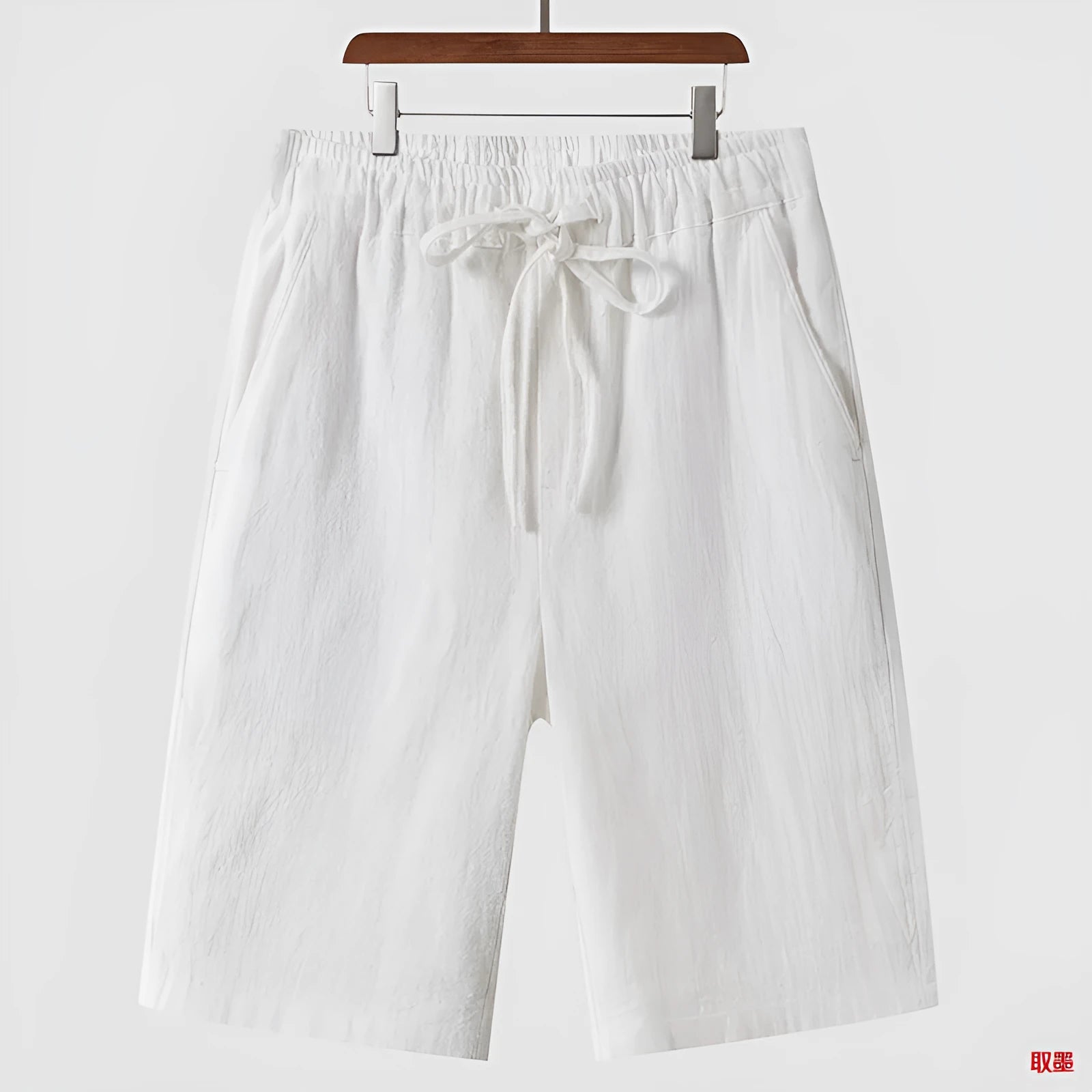 Men's loose-fit linen shorts in a cropped mid-length style with an elastic waistband.