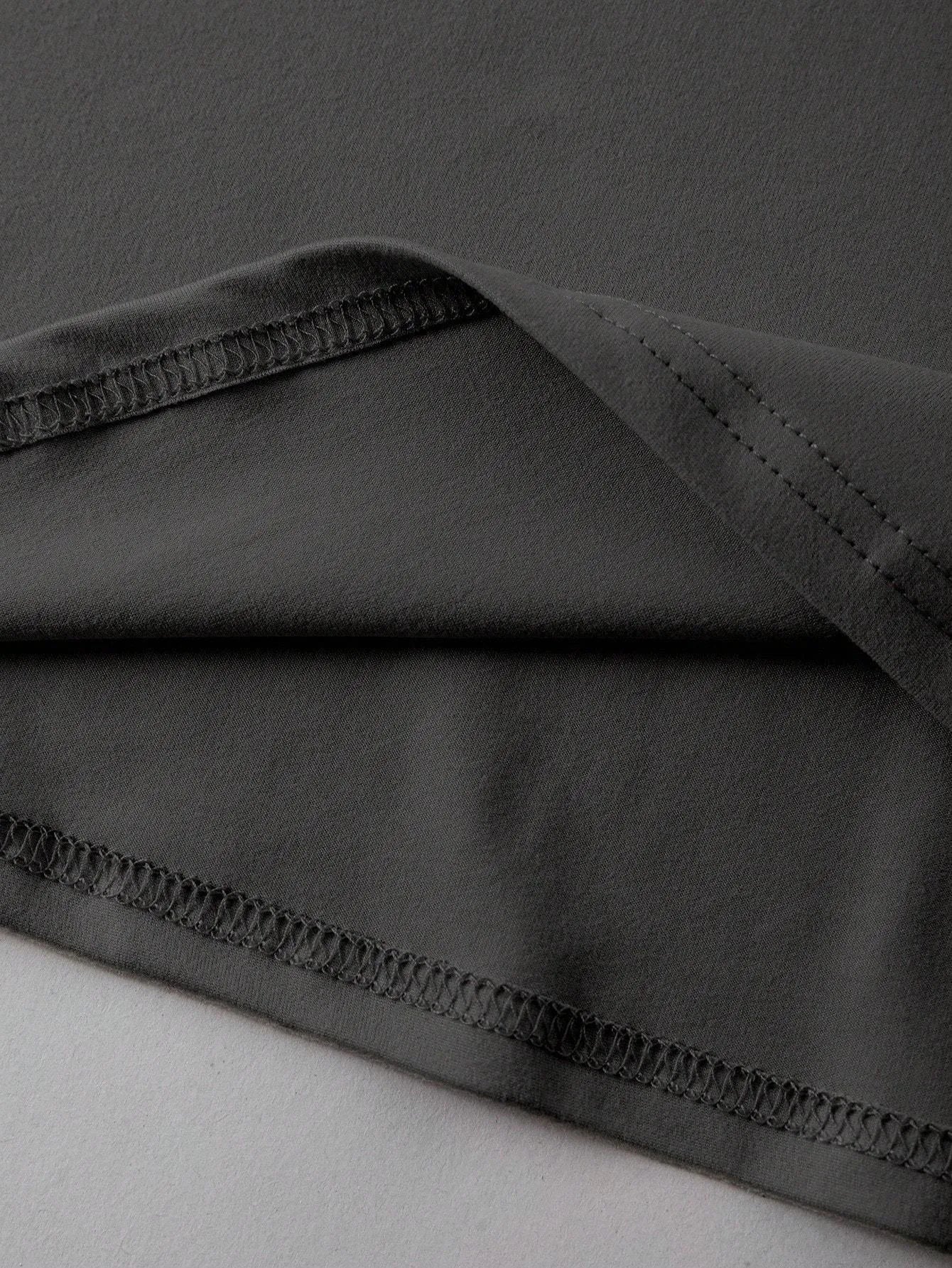 A loose-fitting black cotton T-shirt with short sleeves and a round neck on a hanger.