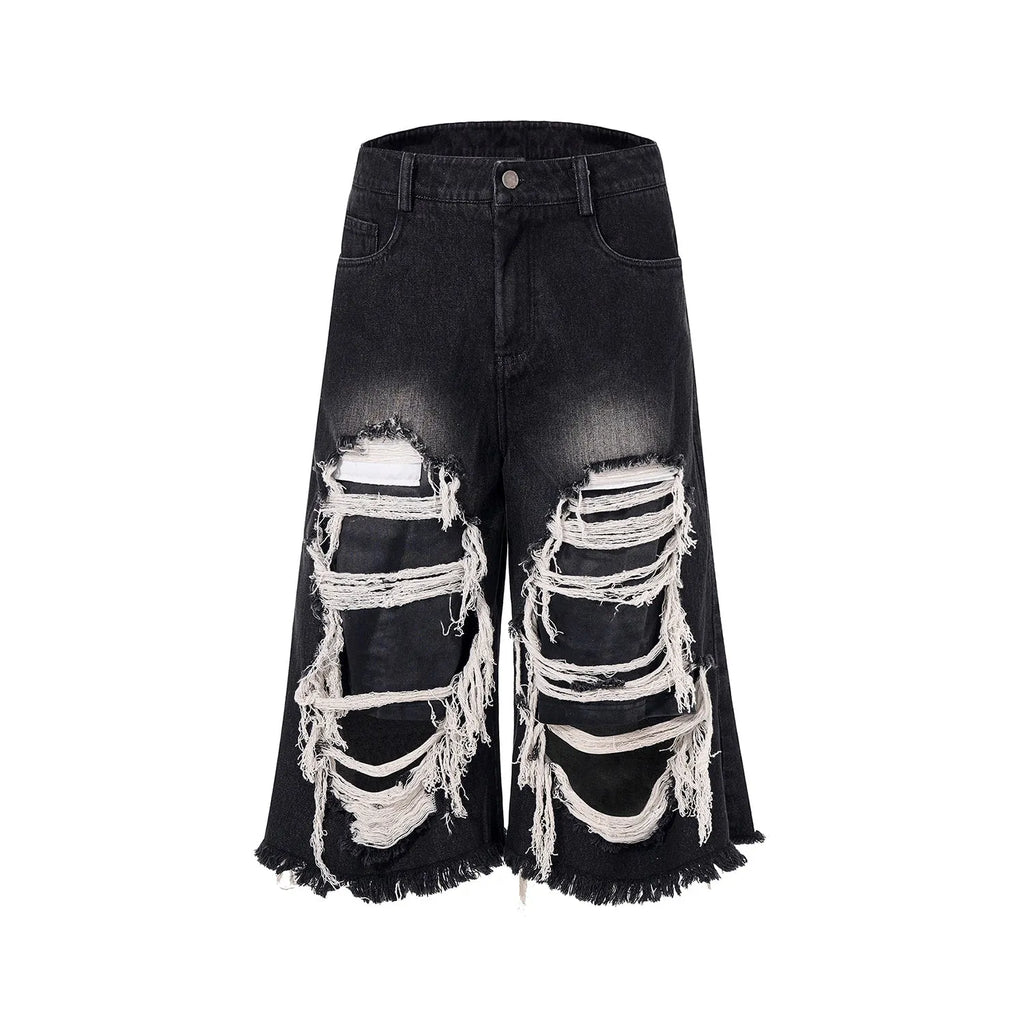 Woman wearing black cropped wide-leg jeans with a mid-high waist and ripped patchwork details