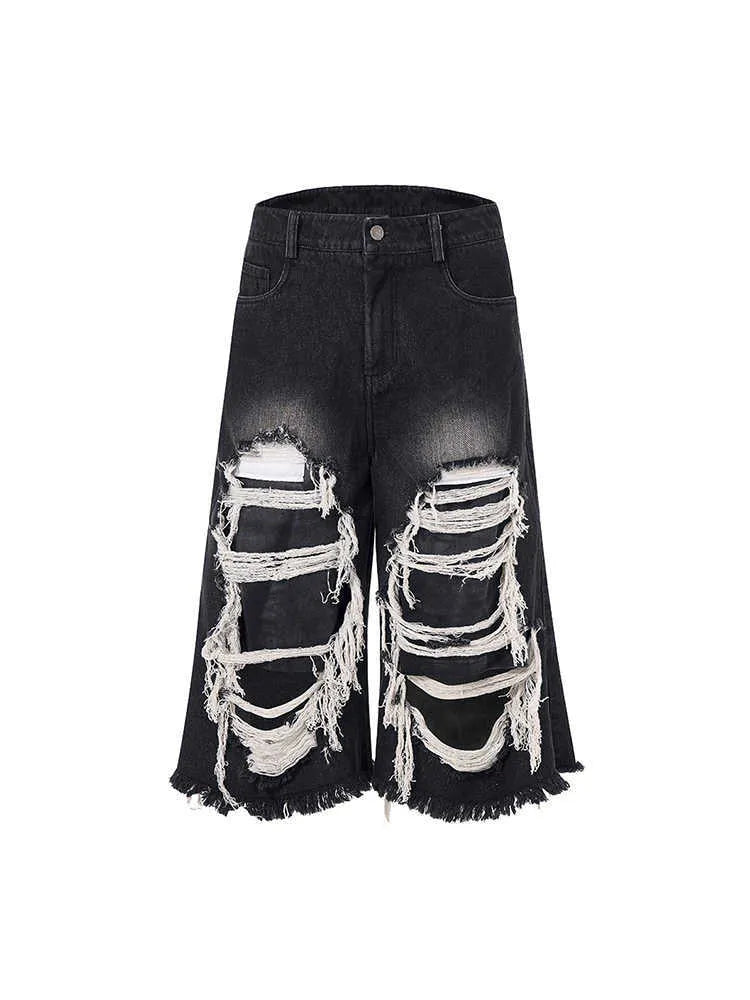 Woman wearing black cropped wide-leg jeans with a mid-high waist and ripped patchwork details