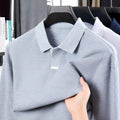 Men's loose-fit cotton polo shirt with lapel collar in grey, shown on a model.
