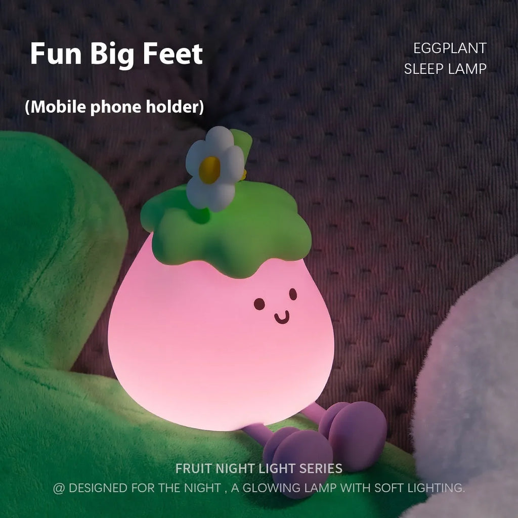 Cartoon eggplant-shaped small night lamp with soft yellow glow, shown next to a broccoli design variant.