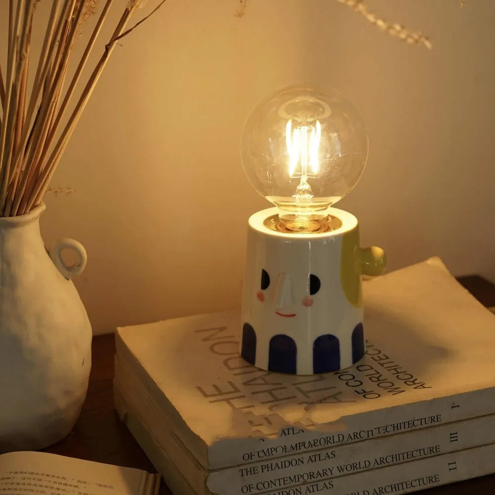 Handmade ceramic table lamp with a spherical ball headlight shade on a ceramic base.