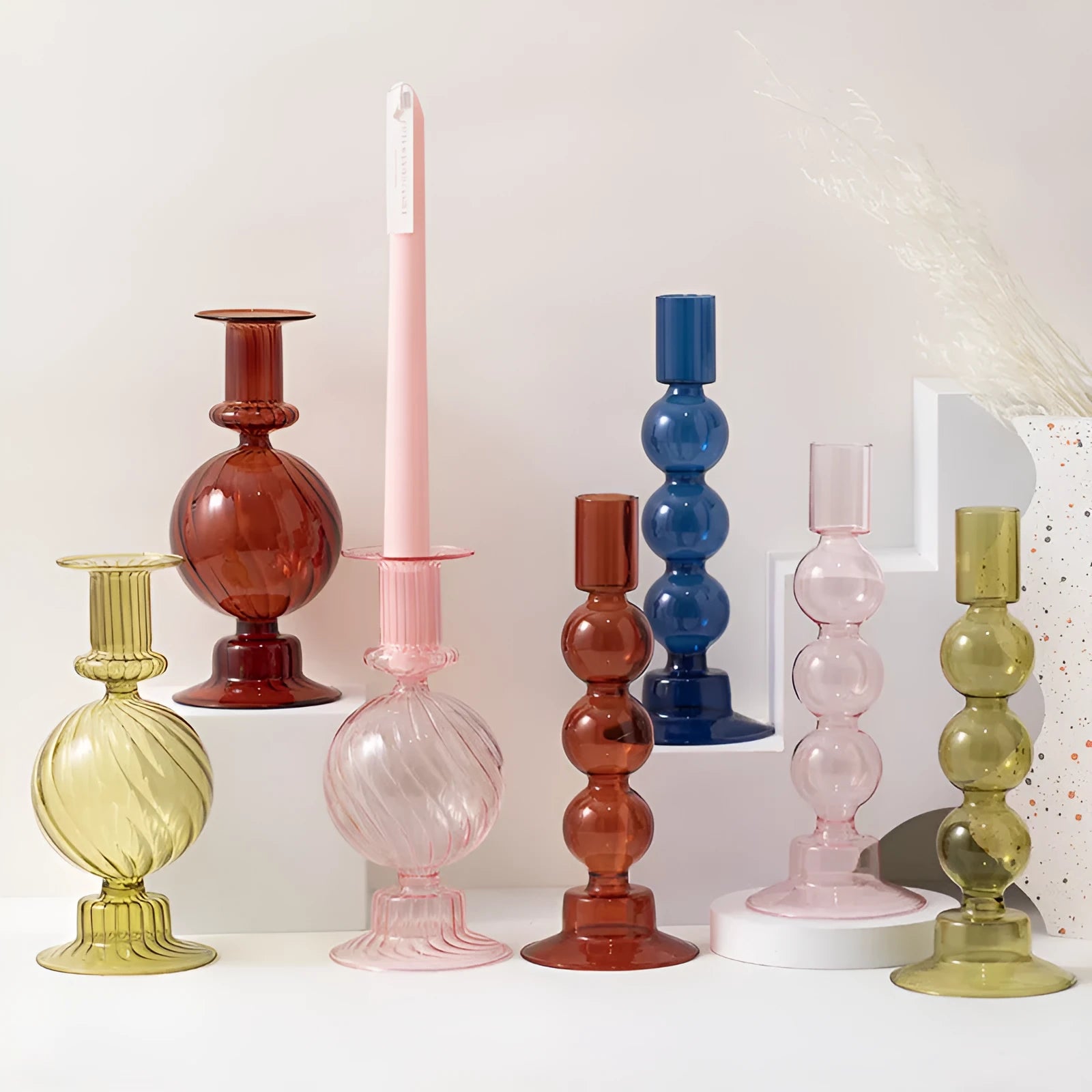 Transparent borosilicate glass three ball mott candle holder in green on a table
