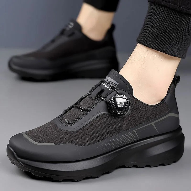 Men's black casual sneakers with a rotating button closure and thick platform sole.