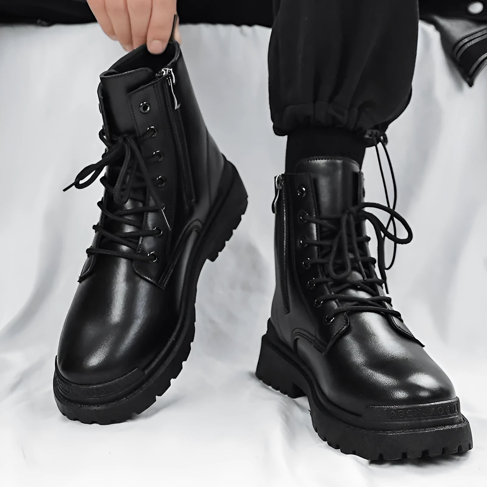 Men's black mid-top British style leather boots with a flat rubber sole.