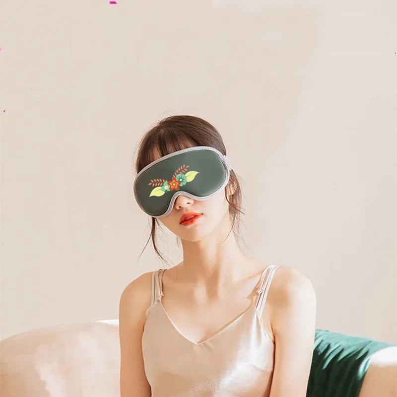 Pink and green portable USB steam sleep massage goggles on a table