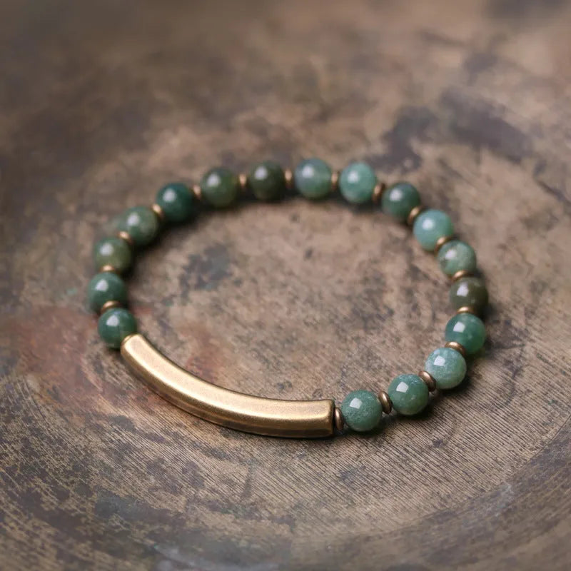 Layered retro ethnic bracelet for men and women with stone beads and brass accents on a wrist.