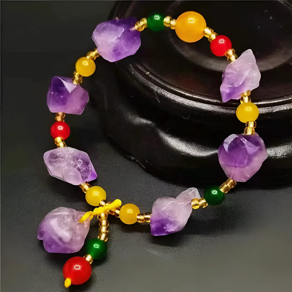 A women's bracelet made of purple natural amethyst beads with a fu character charm.