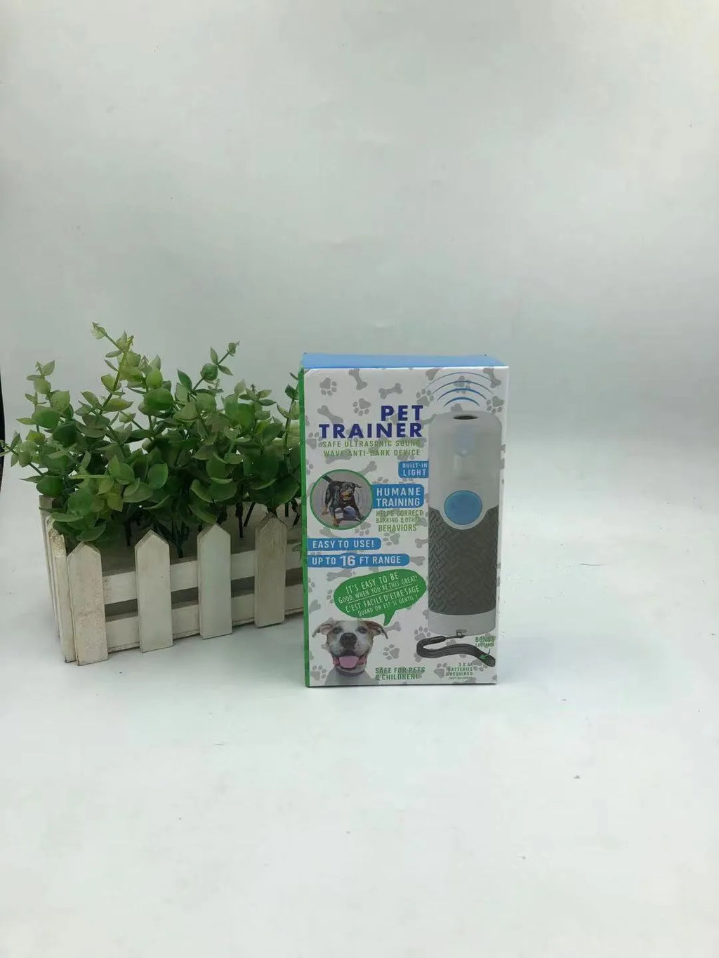 White handheld ultrasonic dog trainer device for bark control on a plain background.