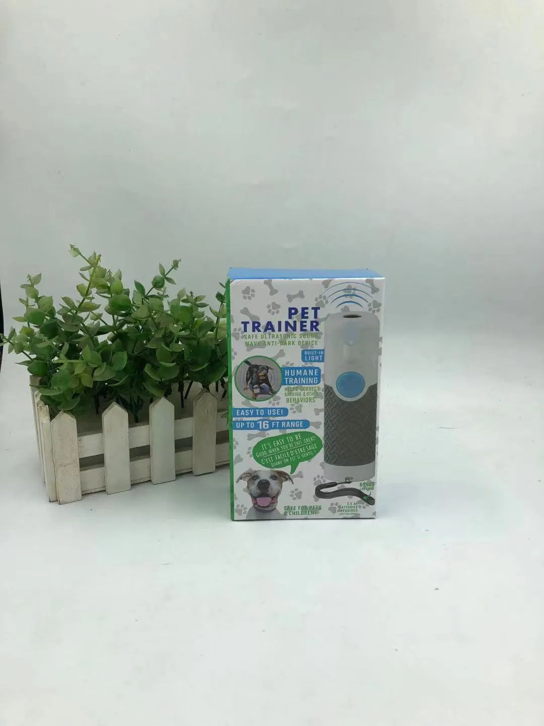 White handheld ultrasonic dog trainer device for bark control on a plain background.