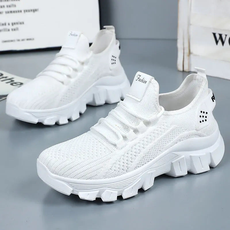 Women's white Flyknit sneakers with round toe and flat heel on a thick PVC sole.