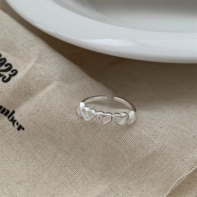 Adjustable copper love heart-shaped ring with electroplated finish on white background