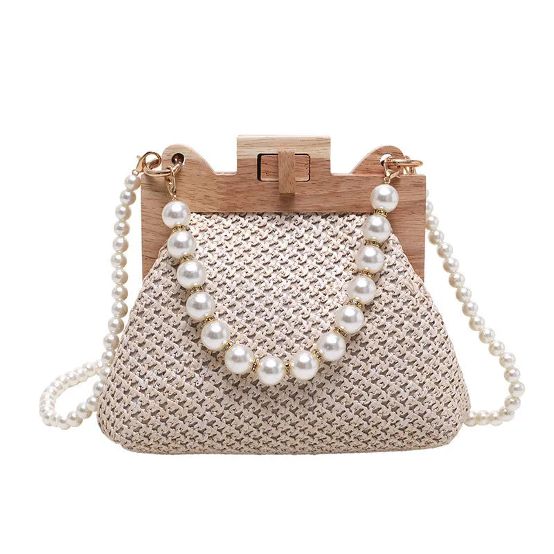 Women's woven straw shoulder bag with pearl chain detailing in horizontal square shape showing internal compartments